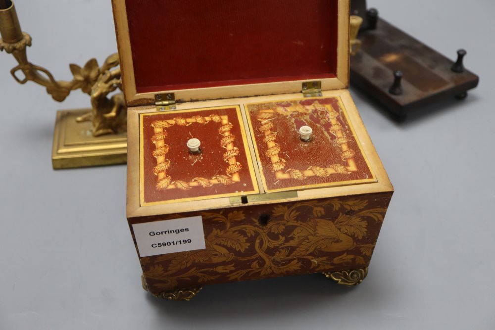 A William IV penwork tea caddy, a pair of ormolu Bacchanalian cherub candlesticks, lacking sconces and a hardwood dish stand